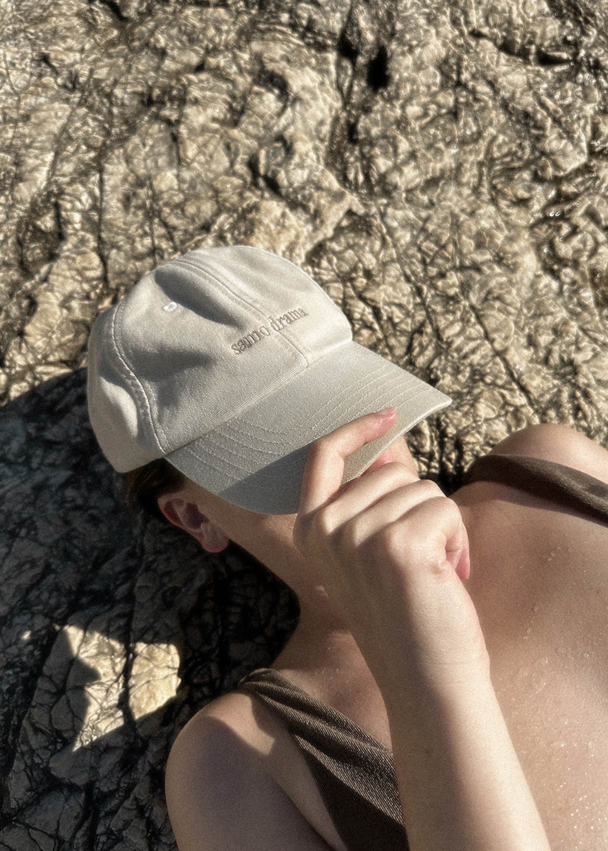 Woman relaxing in the sun wearing the SAMO DRAMA vintage washed cap. Premium aesthetic lifestyle accessories by boja Creative Studio.